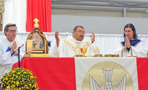 Left photo: Father Rene Canales, moderator of the Camden Diocese’s Charismatic Conference, and Father Ariel Hernandez celebrate Mass for the faithful, pictured in photo. Photos by Alan M. Dumoff