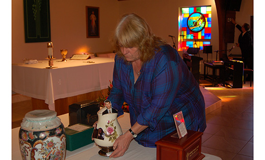 Rosemarie Blaine places the remains of her husband, Gary Michael, on a table set in front of the altar, before a cremated remains group funeral Mass Oct. 29 at Resurrection Church in Marmora.

Photo by James A. McBride