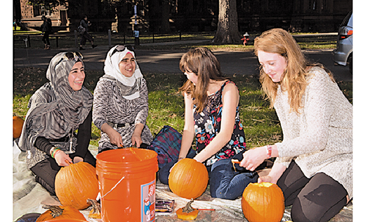 Princeton students and 25 refugee youths now living in New Jersey recently spent a sunny afternoon on campus carving pumpkins before Halloween. The event was co-organized by Princeton’s Office of Religious Life and Catholic Charities in Camden. From left, Syrian refugees Rahaf and Reem get to know Princeton sophomores Stephanie Ward and Lilly Chadwick as they carve pumpkins on the lawn in front of Murray Dodge Hall.

Photo by Denise Applewhite, Office of Communications