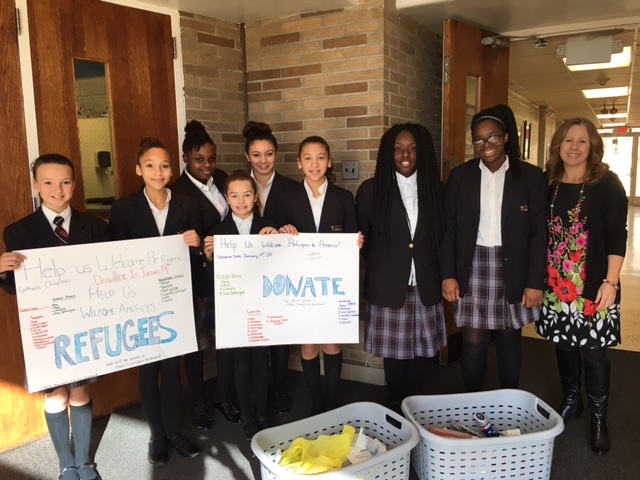St. John Paul II Girl Power participants display some of the items collected for Catholic Charities in support of local refugees. Left to right: students Emily Heck, Angelina Rosario, Olivia Carns, Anaya Griffin, Ava Pilling, Gina Hurd, Naioma Burke, Chi Chi Otith, and moderator Christine Willard.