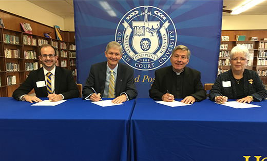 Representatives of Georgian Court University, Lakewood, N.J., and Holy Spirit High School, Absecon, sign an agreement to give the high school students admission advantages, scholarship opportunities, and college course offerings.