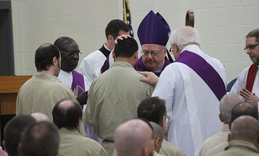 Bishop Sullivan administers holy oil on the forehead of one of four inmates who received the sacrament of confirmation at South Woods Prison, Bridgeton, on April 13. Below, the bishop gives his homily. More than 100 inmates attended Mass.

Photos by Mary McCusker