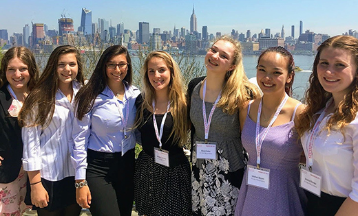 With the New York City skyline in the background, students from Our Lady of Mercy Academy in Newfield pose for a photo during the annual Trading Day Stock Market competition held at Stevens Institute of Technology in Hoboken, N.J., on April 28. Pictured are, from left, Jenna Troyano, Violet Bifulco, Alexandria Patitucci, Mikaela Szamreta, Alyson Daley, Juliehan Nguyen and Jessica Riordan. Below, the students feverishly make a trade.