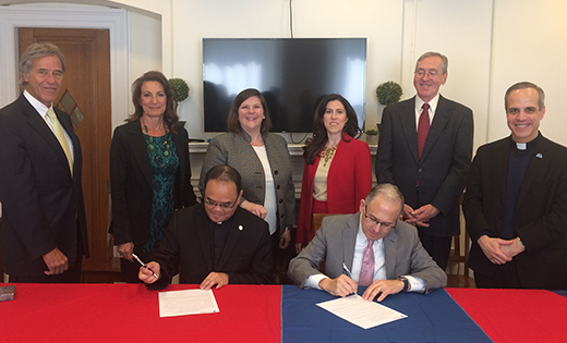 Father Allain Caparas, president and principal of Saint Joseph High School, Hammonton, and Dr. Eugene J. Cornacchia, president of Saint Peter’s University, Jersey City, sign an agreement between the two schools. Standing, from left, are Jeffrey Handler, vice president of enrollment management and marketing, Saint Peter’s; Louise Fourney, director of guidance, Saint Joseph; Elizabeth Sullivan, associate vice president, enrollment/dean of undergraduate admissions, Saint Peter’s; Dr. Mildred A. Mihlon, associate vice president, academic affairs and assessment, Saint Peter’s; Dr. John Walsh, interim vice president, academic affairs, Saint Peter’s; and Father Rocco Danzi, vice president, mission and ministry, Saint Peter’s.