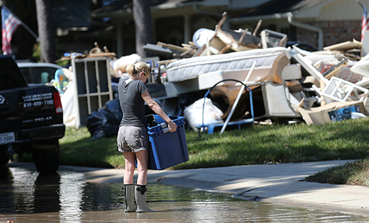 A woman carries items from her flooded home in Houston Sept. 7 in the aftermath of Hurricane Harvey.
CNS photo/Bob Roller