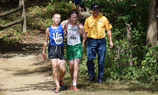 Camden Catholic cross country runner Shane Costello helps an athlete from Union Catholic.

Photo by Sandy Gisone