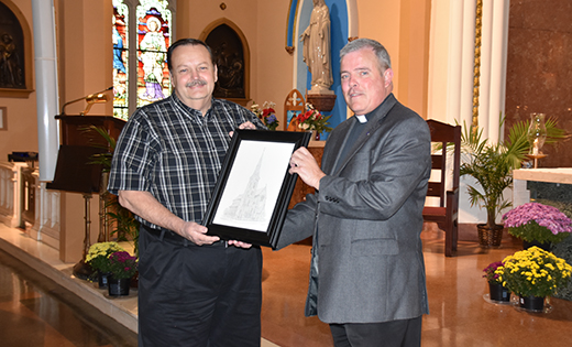 John Moore accepts a drawing of the Cathedral of the Immaculate Conception, Camden, from Father John Fisher, rector.

Photo by James A. McBride