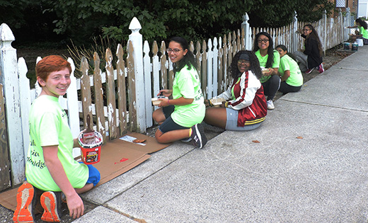 Eighth grade students of Saint Vincent de Paul School, Mays Landing, paint the white picket fence of Bruce and Cathy Foster, who live next to the school. Over the years the Fosters have formed a strong bond with the school community.