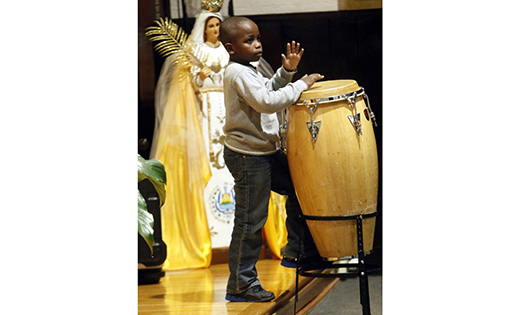 Joeffrey Louis XVI, 6, plays a conga drum during a healing Mass last November at St. Martha Church in Uniondale, N.Y. The liturgy, celebrated in observance of National Black Catholic History Month, was sponsored by the Office of Multicultural Diversity of the Diocese of Rockville Centre, N.Y. Worshippers had an opportunity to venerate a first-class relic of St. Padre Pio after the Mass.
(CNS photo/Gregory A. Shemitz)