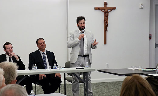 Moustafa Aldoori, a case manager for Catholic Charities, speaks at a panel discussion on refugee resettlement at Saint Thomas More Parish, Cherry Hill. After being kidnapped and held for ransom for nine days when he was 15 years old, he and his family went through a three-year vetting process to come to the United States. Seated are two other Catholic Charities representatives, Daniel Davis, (left), an AmeriCorps volunteer, and Tarek Mousa, an ESL (English as a Second Language) teacher.

Photo by Mary McCusker