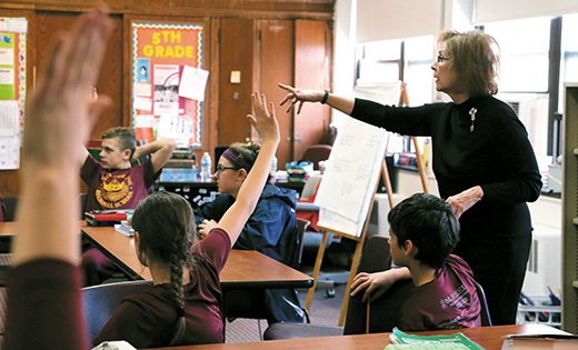 Photo by Debbie Troy -- Teacher Cathy O’Brien discusses literature with her students at Christ the King Regional School, Haddonfield. This year a new language arts curriculum has been implemented in elementary and secondary schools throughout the Diocese of Camden. “The curriculum begins with the end in mind,” says Dr. Bill Watson, director of curriculum and assessment for South Jersey Catholic Schools. “We start by looking at what we want students to be able to do in a subject area by the end of high school and work backward. We have a big picture that can be broken down into units of study in each subject, for every grade, with the related skills our students should be acquiring.”