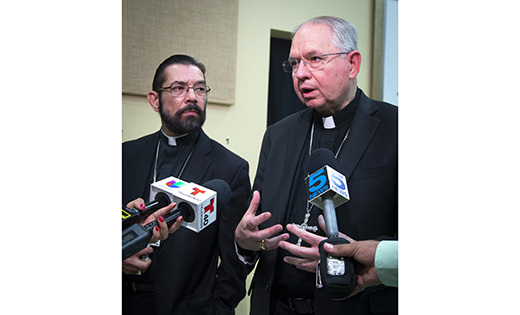 Bishop Daniel E. Flores of Brownsville, left, and Archbishop Jose H. Gomez of Los Angeles, who is vice president of the U.S. Conference of Catholic Bishops, talk to members of the media following a July 2 news conference at the Basilica of Our Lady of San Juan del Valle in San Juan, Texas. During the news conference, the bishops told reporters about the detention center for immigrants they visited earlier in the day in Brownsville, Texas. (CNS photo/Chaz Muth) See BORDER-VISIT-END July 2, 2018.