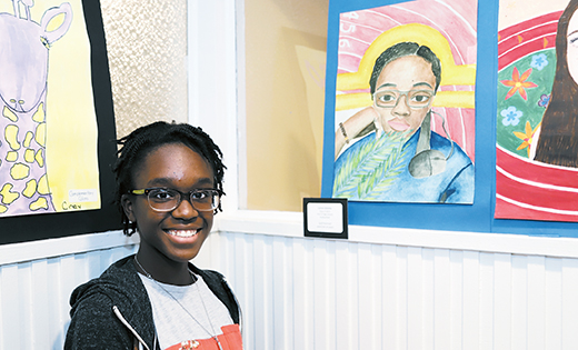 Loren Simms of Paul VI High School, Haddonfield, stands with her watercolor self-portrait. Her artwork, and those of other Catholic school students in South Jersey, are part of the “Art on the Mall” exhibit currently on view at Our Lady Star of the Sea Church, Cape May.