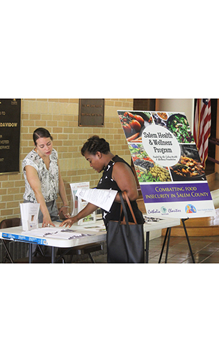 Photo by Mary McCusker

Cristina Chillem of Catholic Charities, left, provides information about the agency’s Salem Health and Wellness Program during an outreach event at Salem Community College.