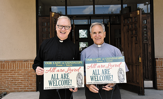 Father Vince Guest, (left), pastor, and Deacon Thomas W. Fargnoli hold signs that are being displayed around Our Lady of Guadalupe Parish, Lindenwold.
