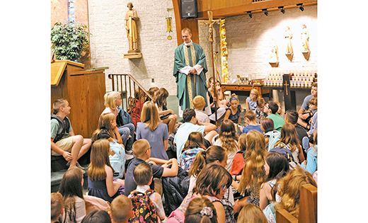 Father Joshua Nevitt talks to children before blessing their backpacks for the beginning of the new school year during Sunday Mass, Sept. 2, at Saint Elizabeth Ann Seton Church, Absecon. Catholic schools opened this week.

Photo by Alan M. Dumoff