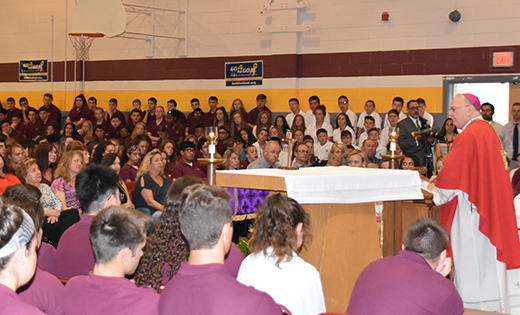 Bishop Dennis Sullivan, celebrates Mass at Gloucester Catholic High School on Sept. 12. Below, students receive Communion.

Photos by Mike Walsh