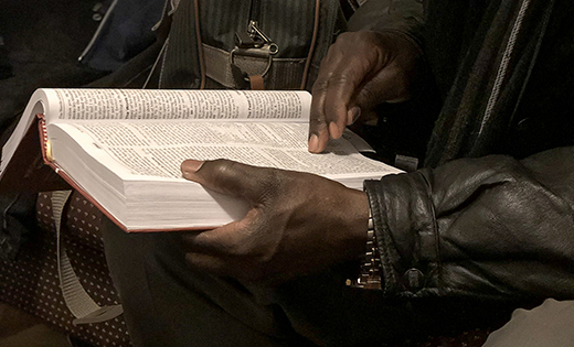 Isaac Wilson, a refugee from Uganda, reads his Bible.