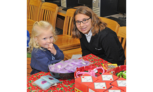 Brielle Carty, a pre-K student at Assumption School, Galloway, gets some help from seventh-grader Eve Amalfitano at the school’s annual Secret Santa Shop

Photo by Alan M. Dumoff