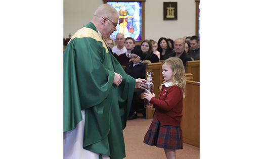 Father Lawrence Polansky, pastor of the Parish of Saint Michael the Archangel, accepts the offertory gift from Isabelle Pence of Saint Michael the Archangel Regional School, Clayton, during Mass to  celebrate Catholic Schools Week, which opened Jan. 27 and ends Feb. 2.

Photo by Mike Walsh