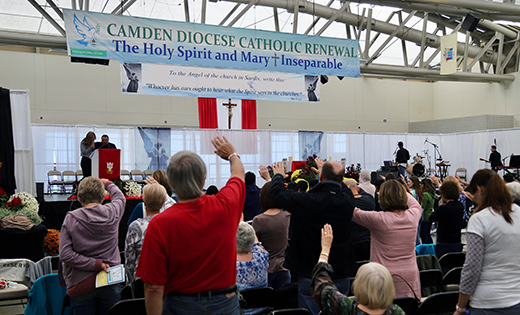 Photo by Mike Walsh
Father René Canales, Bishop’s Delegate for the Catholic Renewal, and Rebekah Hardy, Campus Minister at Rowan University and guest speaker for the conference, lead attendees in praise at the Catholic Renewal Weekend, held at Wildwood Convention Center on Oct. 11-13.