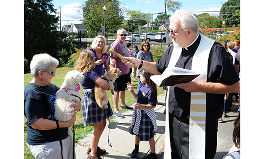 Father Edward F. Namiotka, pastor of Holy Angels Parish, blesses animals. He also blessed stuffed animals that children brought to school for the occasion.