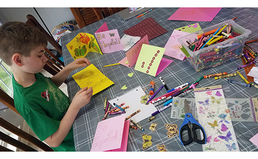 Garrett Sauickie of Saints Peter and Paul Parish, Turnersville, makes cards for priests in nursing homes. Also on the page are children from several parishes.