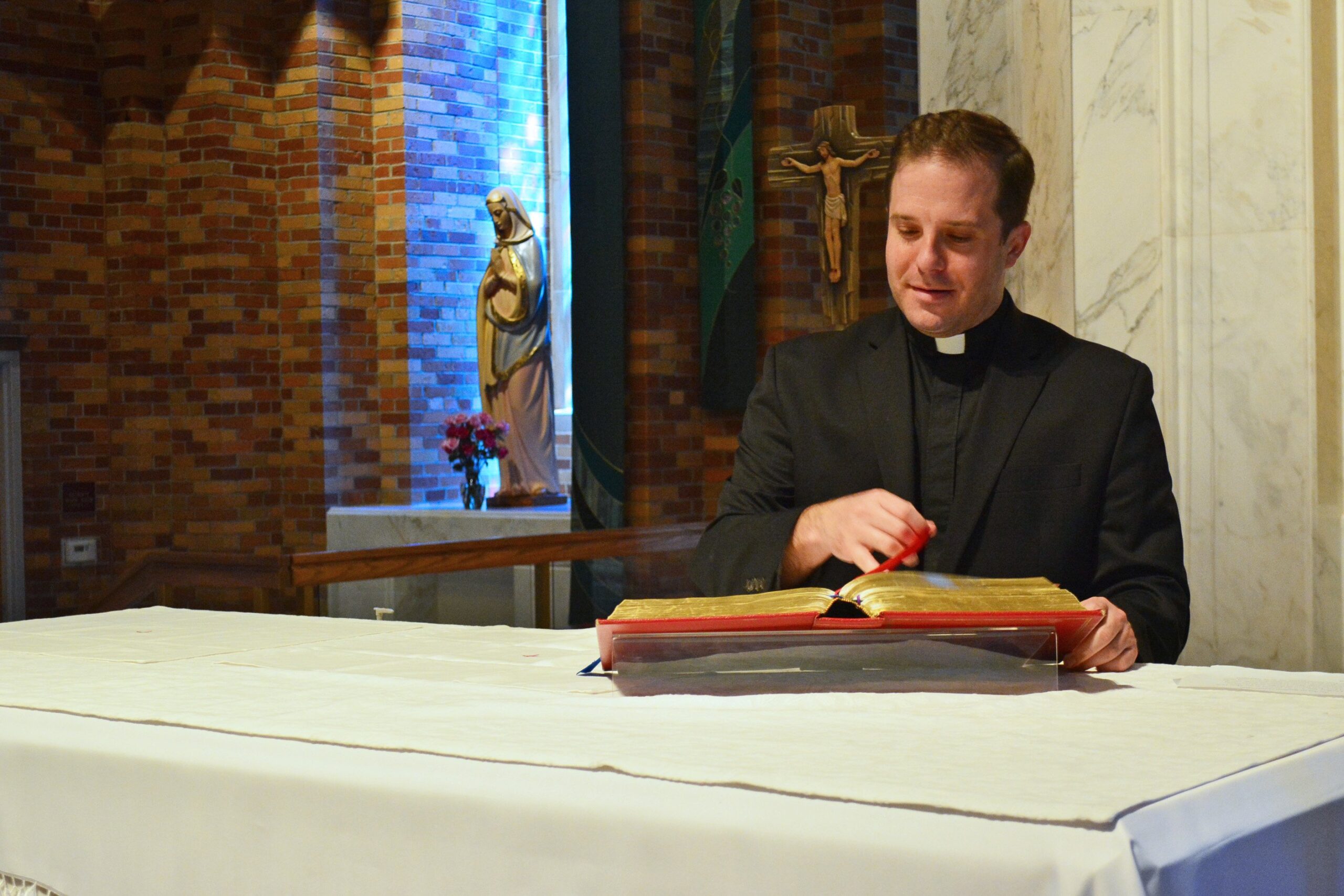 Father Matthew Hood thumbs through the missal at the altar of St. Lawrence Parish in Utica, Mich., Aug. 21, 2020. Finding out he wasnt a priest was a painful realization, but it also came with the grace of knowing Gods providence, he said.  (CNS photo/Michael Stechschulte, Detroit Catholic)