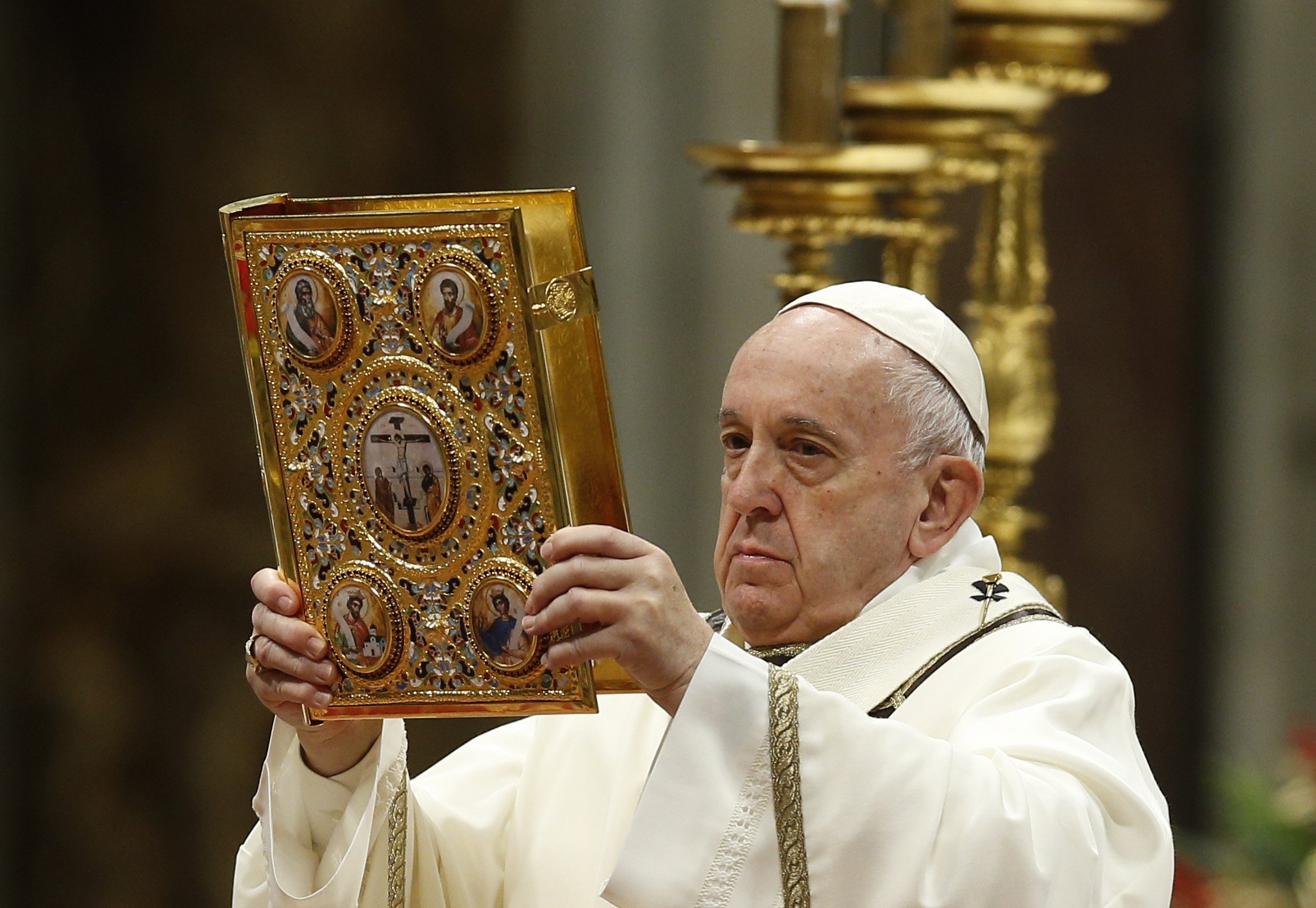 Pope Francis raises the Book of the Gospels as he celebrates Mass marking the feast of the Epiphany in St. Peter's Basilica at the Vatican in this Jan. 6, 2020, file photo. On Jan. 24, the pope will celebrate Mass marking Sunday of the Word of God and will present Bibles to a variety of Catholics, including a professional soccer player, a physician and a student. (CNS photo/Paul Haring)
