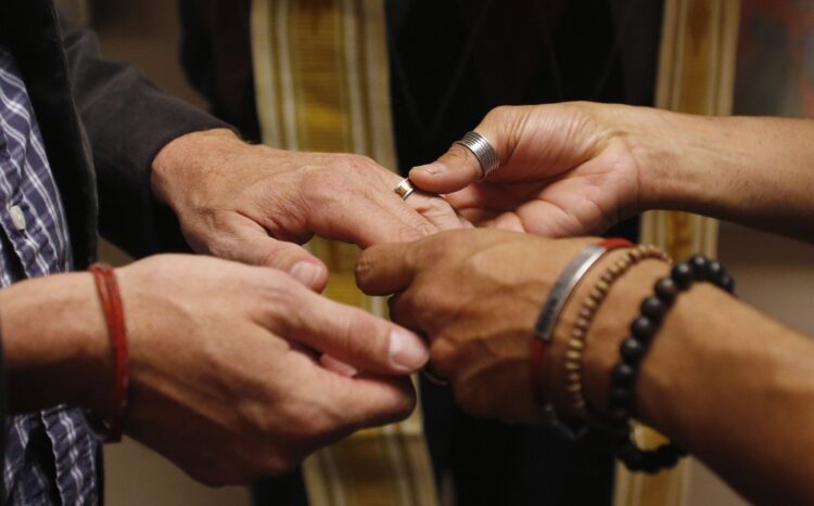 A same-sex couple is pictured in a file photo exchanging rings during a ceremony in Salt Lake City. The Vatican's doctrinal office says in a new note that any form of blessing of same-sex unions is "illicit," but that the negative judgment is on the blessing of unions, not the people, who must be respected. (CNS photo/Jim Urquhar, Reuters)