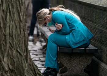 A health care worker in New York City sits on a bench near Central Park March 30, 2020, hunched over and embracing herself. A counselor offers advice on dealing with fear, anxiety, depression or spiritual crisis during the coronavirus (COVID-19) pandemic. (CNS photo/Jeenah Moon, Reuters) See COUNSELOR-ADVICE-ANXIETY-COVID-19 April 2, 2020.