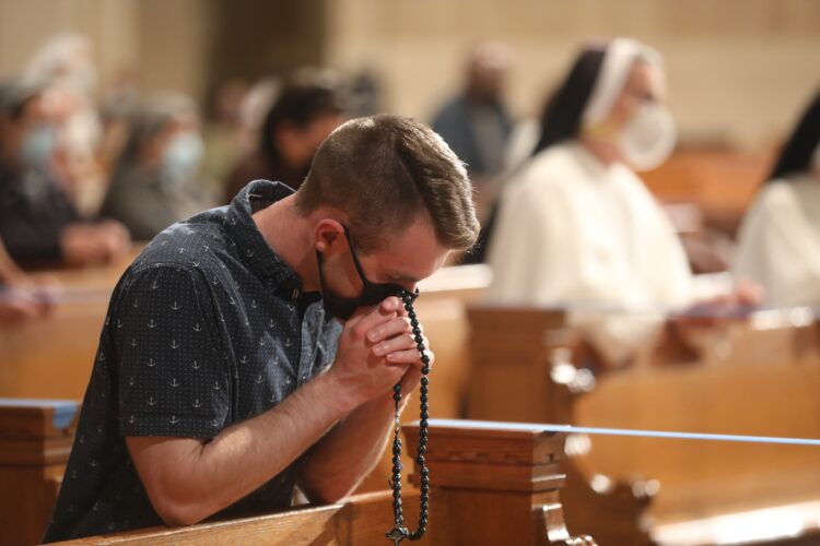 A man prays the rosary at the Basilica of the National Shrine of the Immaculate Conception in Washington May 17, 2021. The rosary, led by Washington Cardinal Wilton D. Gregory, was part of a worldwide effort called by Pope Francis to pray for an end to the coronavirus pandemic. (CNS photo/Andrew Biraj, Catholic Standard)