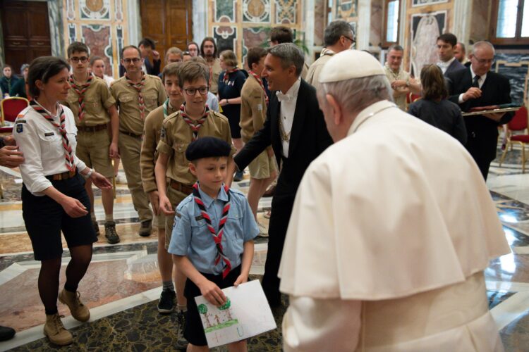 A young Scout offers Pope Francis a drawing May 14, 2021, at the end of an audience at the Vatican for French Catholic Scouts celebrating the 50th anniversary of their association. (CNS photo/Vatican Media)