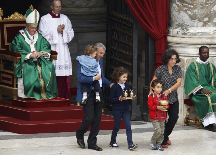 Pope Francis watches as a family carries offertory gifts to the altar during a Mass for catechists in St. Peter's Square at the Vatican in this Sept. 29, 2013, file photo. In a document released May 11, 2021, Pope Francis  instituted the "ministry of catechist." (CNS photo/Paul Haring)