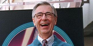Television personality Fred Rogers, of public television's "Mister Rogers' Neighborhood," laughs as he poses with a plaque he received in 1998 at a ceremony to unveil his star on the Hollywood Walk of Fame. It has been 50 years since the popular TV program first aired. Rogers died in 2003 in Pittsburgh. (CNS photo/Reuters)