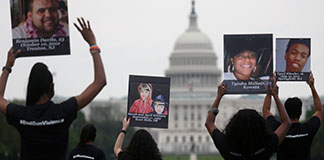 Survivors, family and friends of victims of gun violence hold up photographs of people lost to gun violence after delivering a "State of the Union on the Gun Violence Crisis in America" on the National Mall in Washington April 29, 2021. (CNS photo/Leah Millis, Reuters)