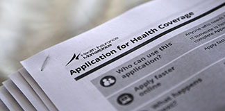The federal government forms for applying for health coverage are seen Oct. 4 at a rally held by supporters of the Affordable Care Act outside the Jackson-Hinds Comprehensive Health Center in Jackson, Miss. Catholic hospitals are among some of the groups and businesses helping people understand and apply for insurance under the new health care law. (CNS photo/Jonathan Bachman, Reuters) (Nov. 1, 2013) See WASHINGTON LETTER Nov. 1, 2013.