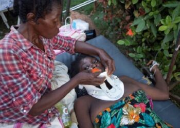 An injured woman is assisted in Les Cayes, Haiti, Aug. 15, 2021, following magnitude 7.2 earthquake the previous day. (CNS photo/Estailove St-Val, Reuters)