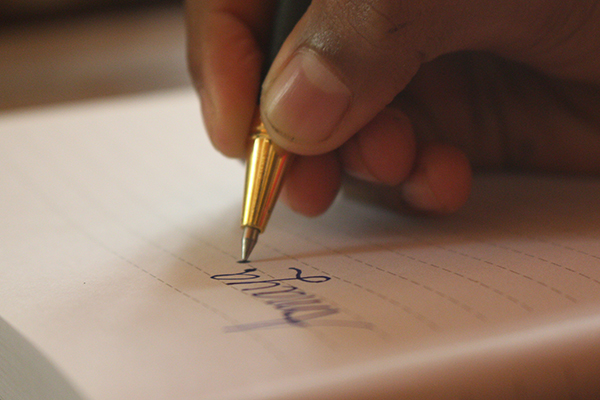 Close up picture of a writting a word with a ink pen with a blurry background