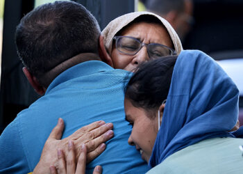 Afghan refugees at Dulles International Airport in Dulles, Va., embrace family members Sept. 2, 2021, before boarding buses that will take them to a processing center. (CNS photo/Evelyn Hockstein, Reuters)