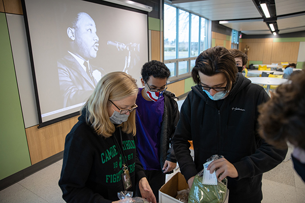Director of Campus Ministry, Jen Larosa, helps students fill a box with toiletries for the Cherry Hill Food Pantry, at Camden Catholic High School in Cherry Hill, NJ on Monday, January 17, 2022.