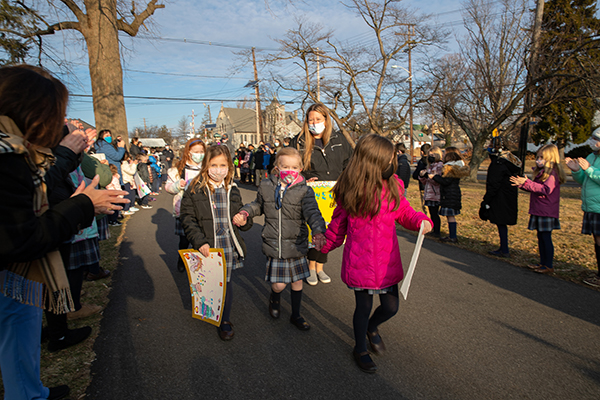 Classmates run with first grader, Adelyn McWilliams, at Holy Angels Catholic School in Woodbury, NJ on Monday, January 24, 2022. Adelyn was rushed from school to a hospital in December after developing symptoms from a tumor in her brain.