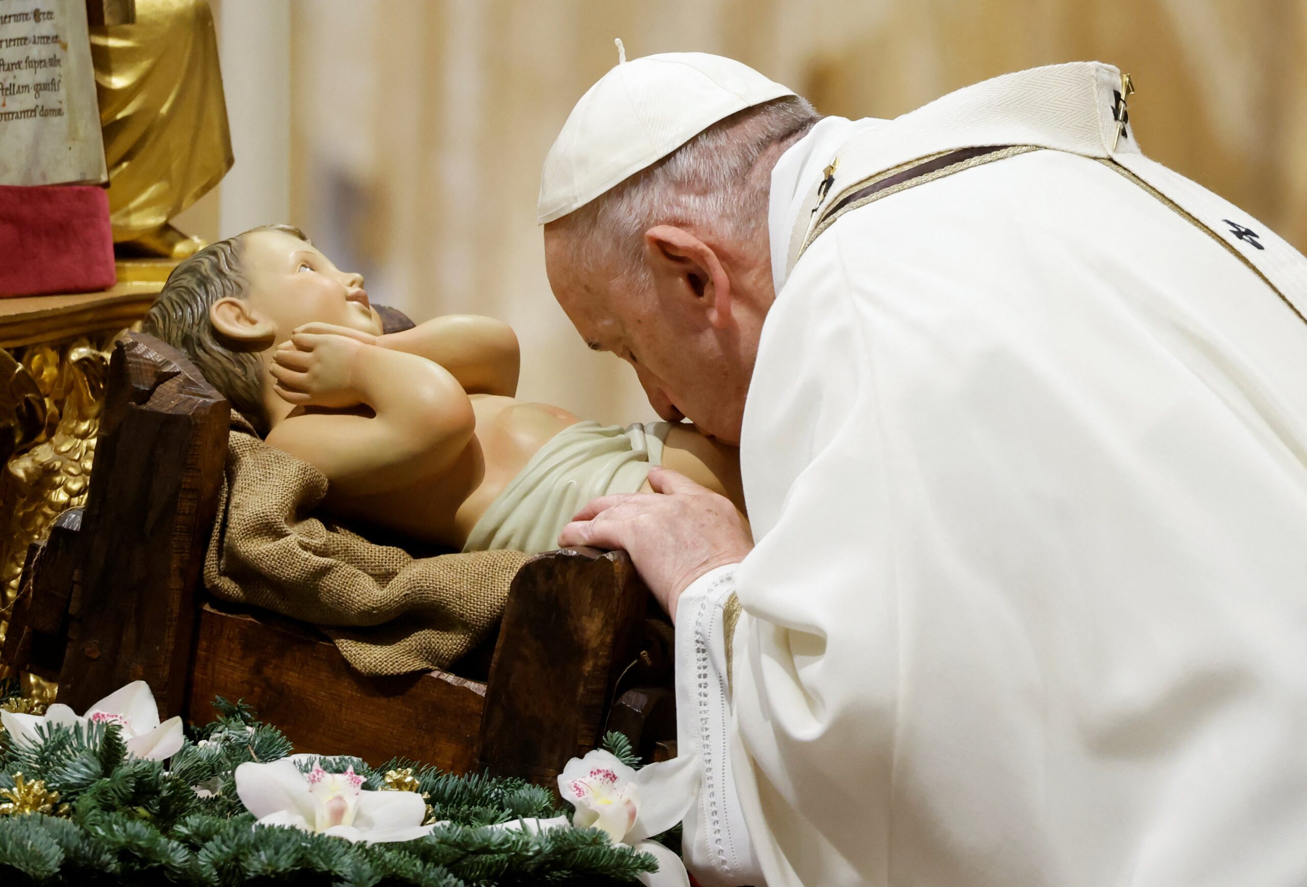 Pope Francis kisses a figurine of the baby Jesus as he celebrates Mass for the feast of Epiphany in St. Peter's Basilica at the Vatican Jan. 6, 2022. (CNS photo/Yara Nardi, Reuters)