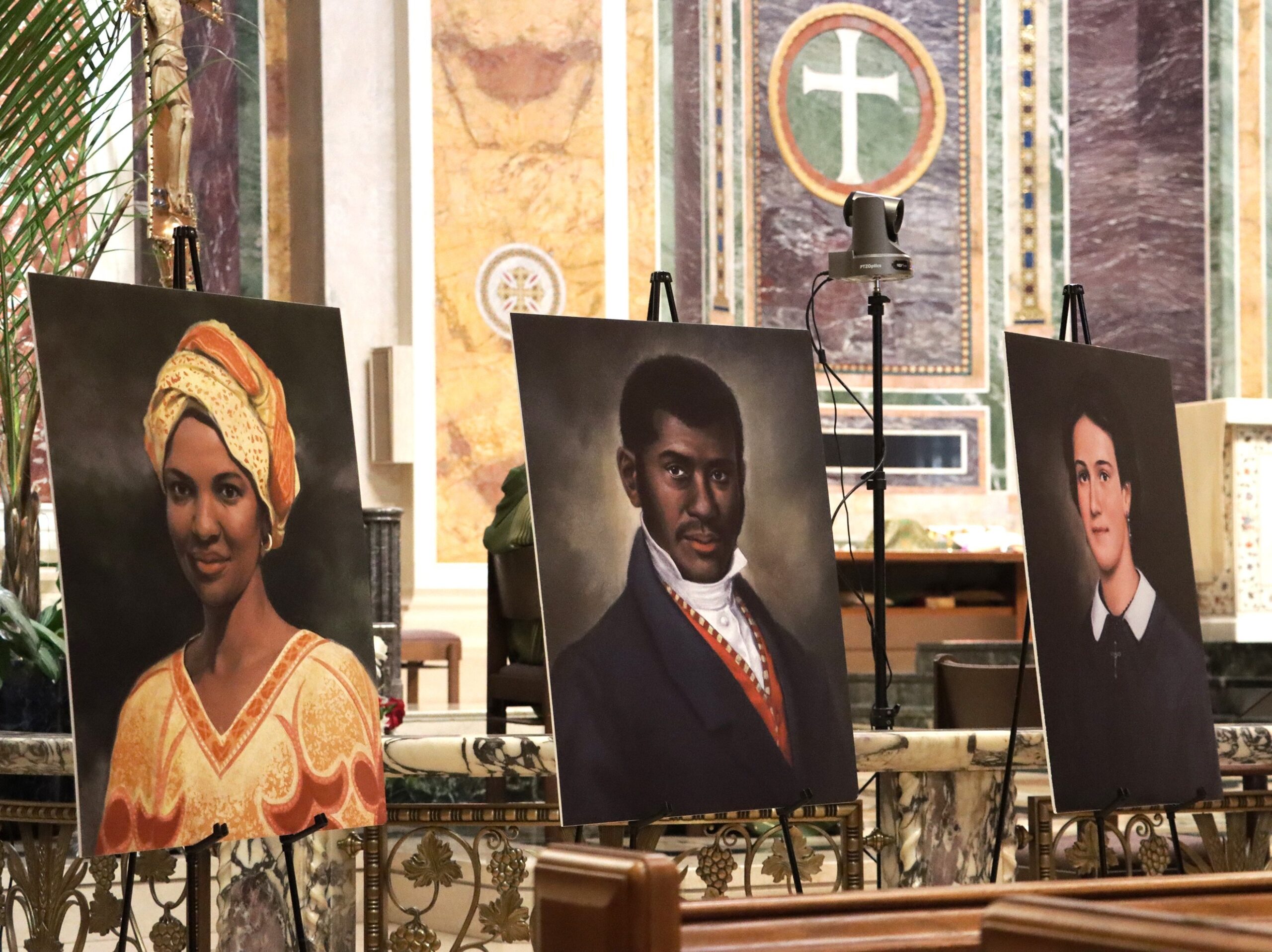 Portraits of three of six Black American Catholics who are sainthood candidates are seen at St. Matthew's Cathedral Feb. 6, 2022, during a Mass marking Black History Month. Pictured from left are: Sister Thea Bowman, a Franciscan Sister of Perpetual Adoration, known for her singing, speaking and evangelizing; Pierre Toussaint, a Haitian American who was brought to New York City as a slave and became a hairdresser and philanthropist after becoming free; and Mother Henriette Delille of New Orleans, a descendant of slaves who founded the Sisters of the Holy Family in 1836. (CNS photo/Javier Diaz, Catholic Standard)