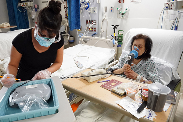 Patient Camille Watts performs a breathing exercise as respiratory therapist Elaina Bongiovanni charts her progress at Good Samaritan Hospital Medical Center in West Islip, N.Y., on World Day of the Sick, Feb. 11, 2021. The observance, instituted by St. John Paul II in 1992 and celebrated annually on the feast of Our Lady of Lourdes, affirms the church's duty to remember and serve the sick and the suffering. (CNS photo/Gregory A. Shemitz)