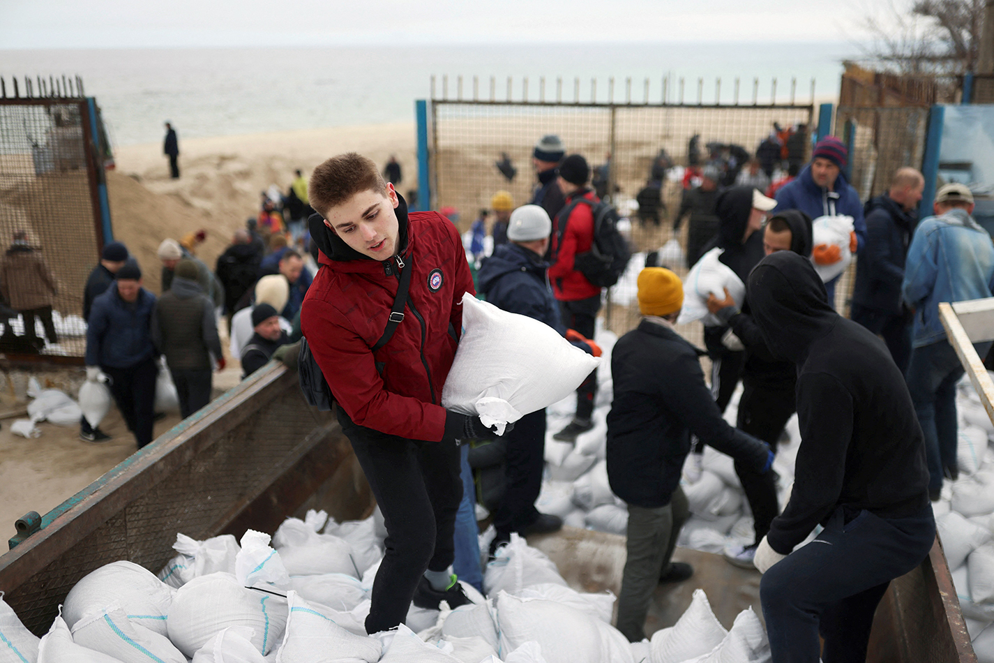Residents carry sandbags to build a barrier to help defend the continuing Russian invasion of Ukraine in Odessa March 14, 2022. (CNS photo/Nacho Doce, Reuters)