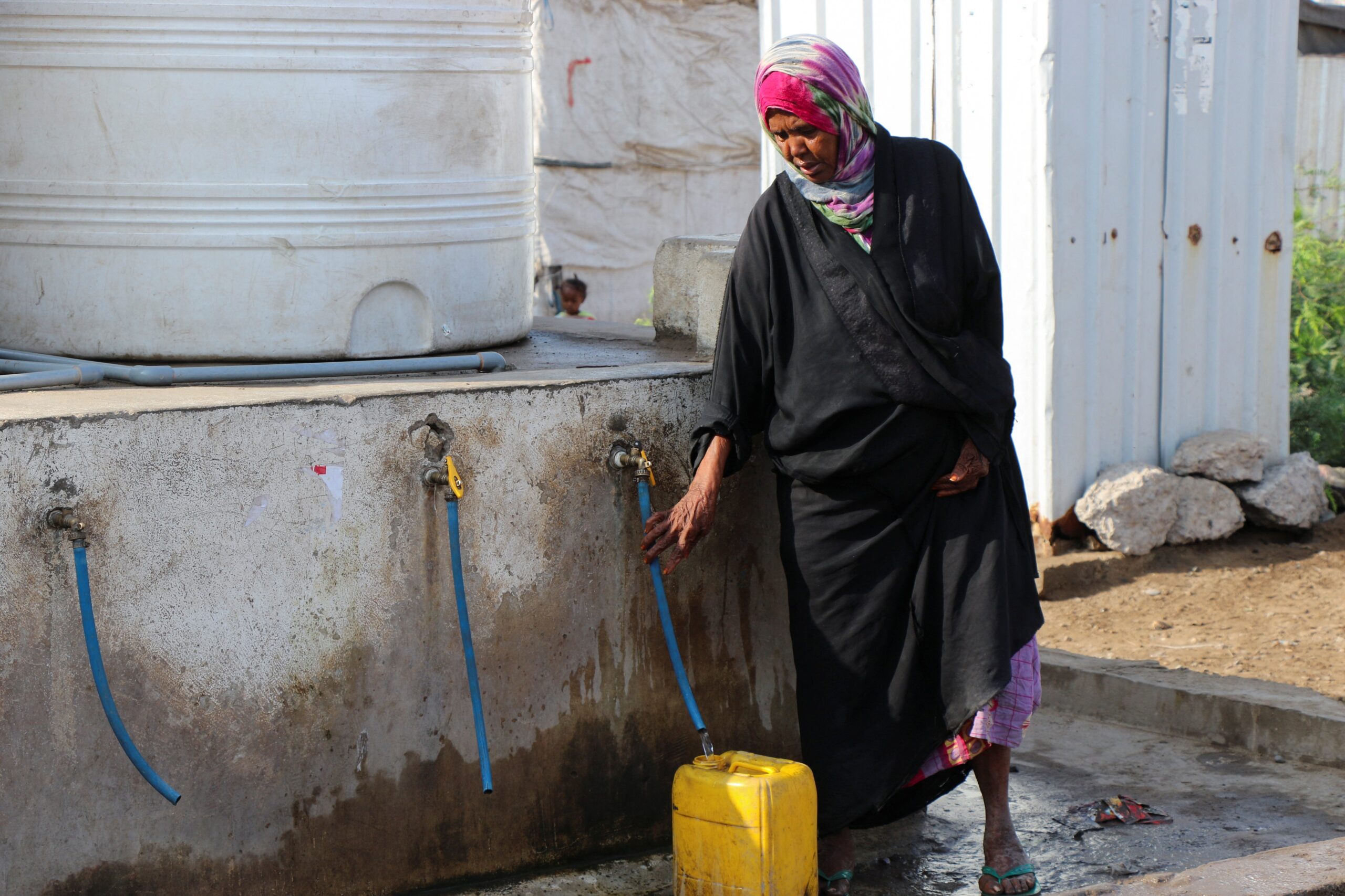 A woman fills a can with water at a makeshift camp for internally displaced people in Aden, Yemen, March 15, 2022. Pope Francis said the real battles people should be fighting are ones against hunger, thirst, disease, poverty and slavery. He made his remarks during a March 21 audience with the volunteer organization called, "I was thirsty," which is dedicated to getting potable water to people who have none. (CNS photo/Fawaz Salman, Reuters)