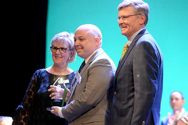 Michael Canaris, center, poses for a photo with president Mary Whipkey, and chairman Jack Wixted, after being inducted into the Camden Catholic High School Hall of Fame during the schools 14th Annual Hall of Fame Induction Ceremony, Saturday, April 9, 2022.  Joe Warner/For The Catholic Star Herald.
