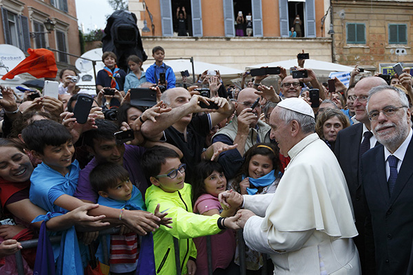 Pope Francis greets the crowd as he arrives to visit the Basilica of Santa Maria in Rome's Trastevere neighborhood June 15. The pope visited members of the Community of Sant'Egidio, which has its headquarters near the basilica. At right is Andrea Riccardi, founder of the community. (CNS photo/Paul Haring) (June 16, 2014) See POPE-SANTEGIDIO June 16, 2014.