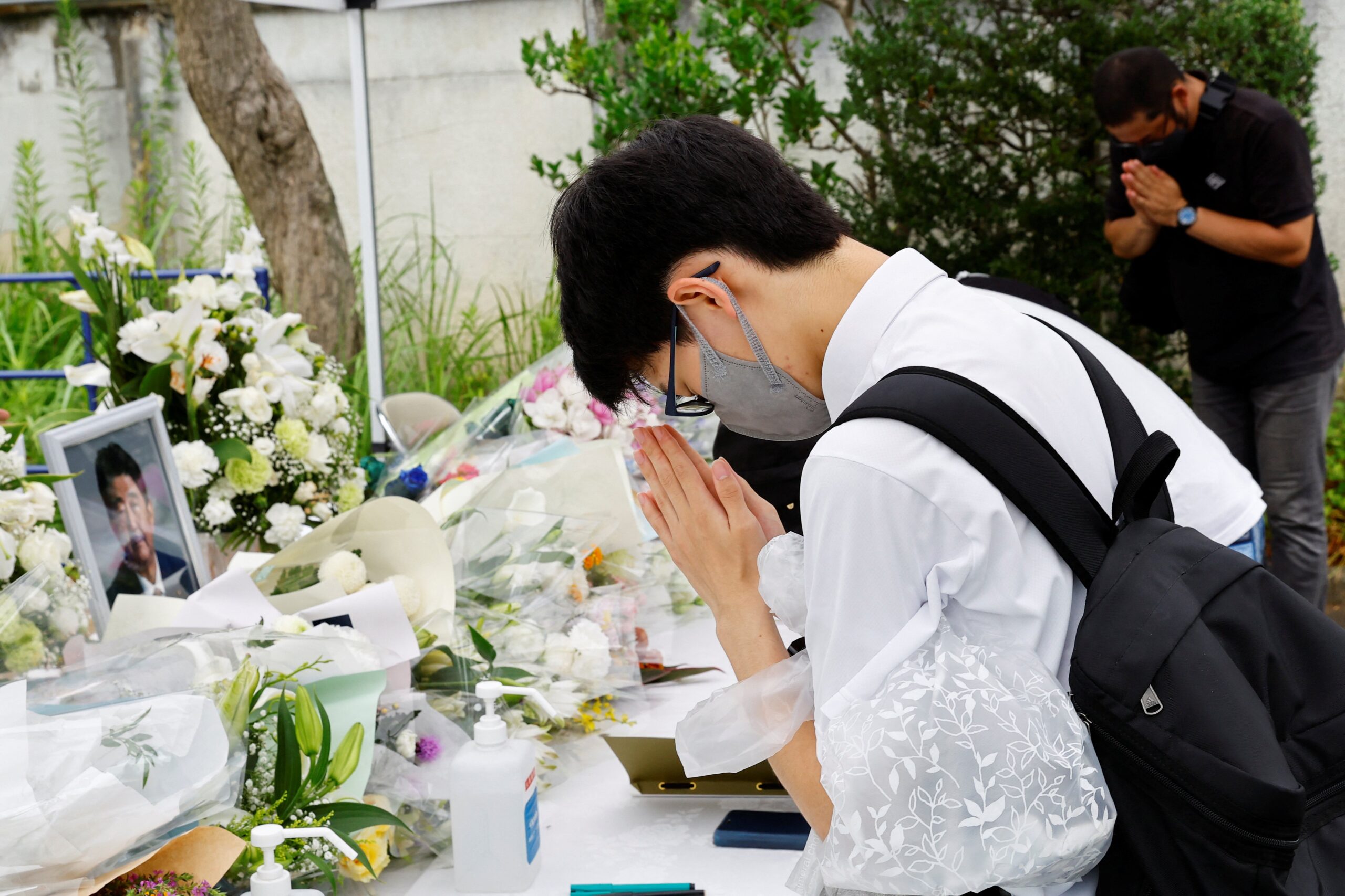 Mourners pray for the late former Japanese Prime Minister Shinzo Abe at the  headquarters of the Japanese Liberal Democratic Party in Tokyo July 12, 2022. Archbishop Isao Kikuchi of Tokyo strongly condemned the July 8 assassination of Abe, and deplored violence as a means of solving political differences. (CNS photo/Kim Kyung-Hoon, Reuters)